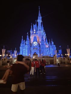 people standing in front of a castle at night