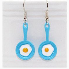 Egg In A Pan” Enamel Earrings Charm Approx. 0.9 Cm (H) X 2.1cm(W) Nickel Free Ear Wires. Comfortable And Light Weight. Rubber Stoppers Included. Earrings Will Come On An Earring Card Novelty Blue Drop Earrings, Blue Fun Drop Earrings, Blue Fun Dangle Jewelry, Blue Drop Earrings Fun Style, Fun Blue Nickel-free Jewelry, Fun Blue Dangle Jewelry, Blue Dangle Jewelry With A Fun Style, Blue Handmade Novelty Earrings, Handmade Blue Novelty Earrings