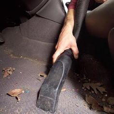 a man is vacuuming the floor in his car