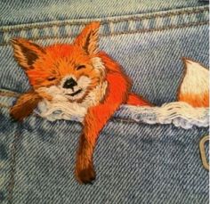 a drawing of a sleeping fox in the back pocket of someone's jean pants