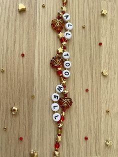 a wooden table topped with lots of beads and christmas decorations on top of each other