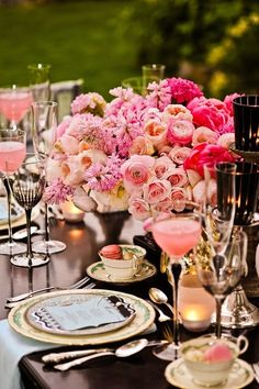 the table is set with pink and white flowers