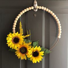 two sunflowers are hanging on the front door with beaded garland around them