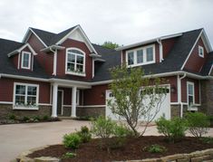 a large red brick house with lots of windows on the front and side of it