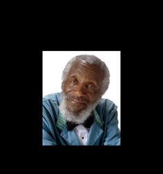 an older man wearing a blue shirt and bow tie with his arms crossed, looking at the camera