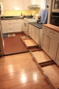 an image of a kitchen being remodeled with wood flooring and new cabinets in place