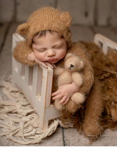 a baby sleeping in a crib with a teddy bear