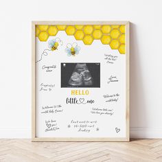 a wooden frame with the words hello little one written on it and bees around it