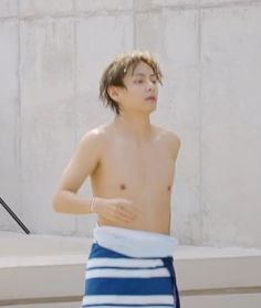 a shirtless young man wearing a towel around his waist