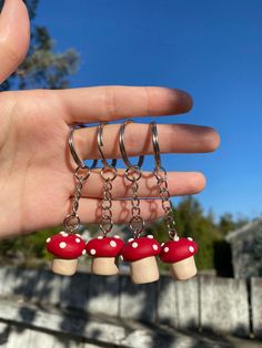 a person is holding three small mushrooms in their hand, with chains attached to them