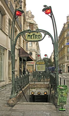 a street scene with focus on the entrance to an underground tunnel in the middle of the road