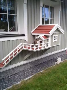 a dog house that is on the side of a building with stairs leading up to it