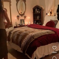 a woman taking a photo of a bed with leopard print comforter and red bedspread