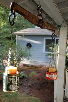 two candles are hanging from a porch beam on the back patio, one is filled with oil and the other is empty