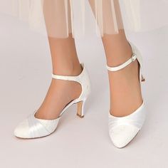 a close up of a person wearing white shoes with high heels and a veil on their feet