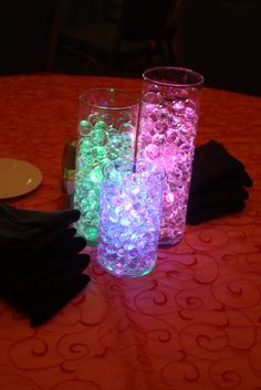 two vases filled with water sitting on top of a table