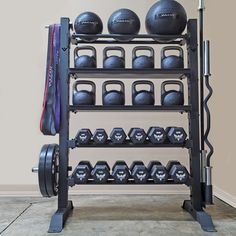 a gym rack with several dumbs and two sets of exercise balls on each shelf