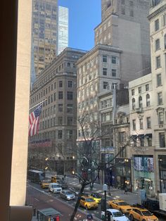 a city street filled with lots of traffic next to tall buildings on either side of the road