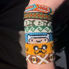 a person's arm covered in bracelets with different designs on each one wrist