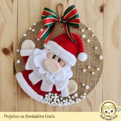 a santa clause ornament hanging on a wooden wall with beads and ribbon around it