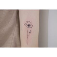 a single flower tattoo on the arm