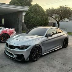 two cars parked next to each other in front of a garage