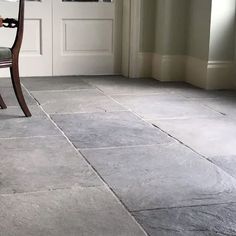 a chair sitting in front of a door on top of a tile floor next to a doorway