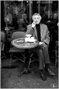 a black and white photo of a man sitting at a table