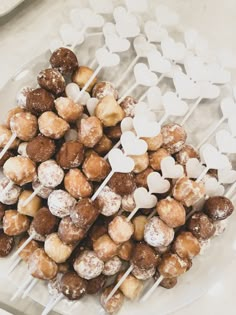 there are many heart shaped lollipops on the plate and one is filled with marshmallows