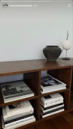 a book shelf with books and a vase on top