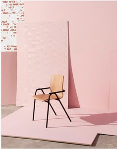 a wooden chair sitting on top of a pink floor next to a white and brown wall