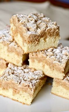 several pieces of cake sitting on top of a white plate with powdered sugar toppings