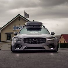 a car parked in front of a building with a roof box on it's top