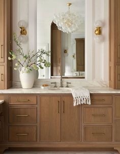 a bathroom with wooden cabinets and marble counter tops