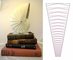 a stack of books sitting on top of each other next to a white paper sculpture