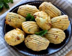 a black plate topped with cheesy biscuits covered in cheese