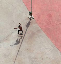 a man riding a skateboard down the side of a cement road next to a traffic light