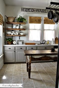 a kitchen filled with lots of counter space and open shelving above the stove top