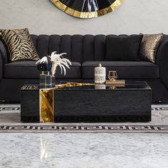 a living room with a black couch, gold accents and a large clock on the wall