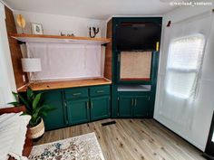 a living room with green cabinets and a white rug