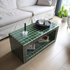 a living room with a white couch and green tiled table