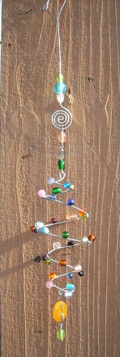 a wind chime hanging from the side of a wooden wall with glass beads on it