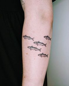 a person with a tattoo on their arm has fish drawn on it's left arm