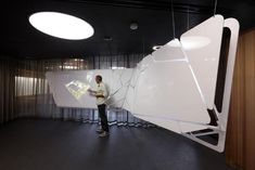 a man standing in front of a large white piece of art that has been smashed