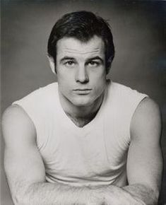 an old black and white photo of a man with his arms crossed looking at the camera