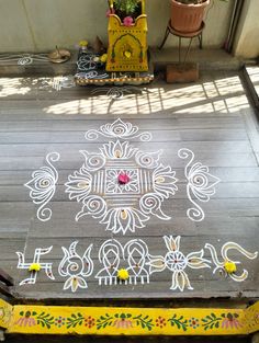 a wooden floor covered in white chalk on top of a hard wood floor next to a potted plant