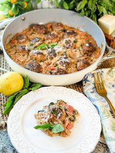 a white plate topped with food next to a pan filled with meat and veggies