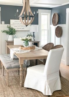 a dining room table with chairs and a chandelier hanging from it's ceiling