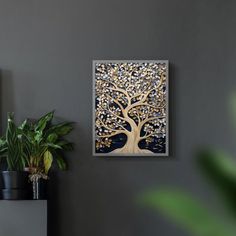 a painting hanging on the wall next to a plant and potted plant in front of it