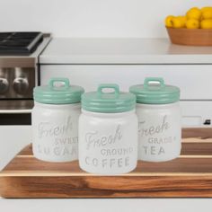 three glass jars sitting on top of a cutting board